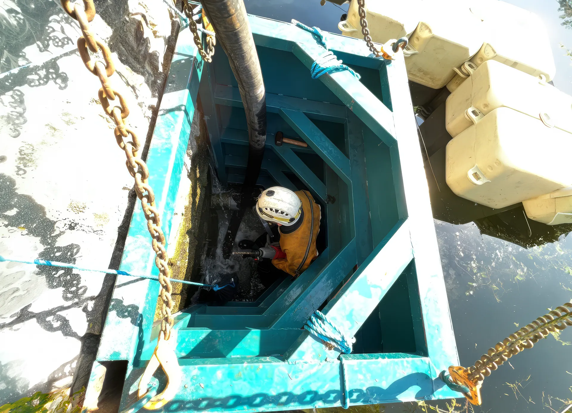 High Water engineer working within a confined space access chamber during temporary water engineering operations.