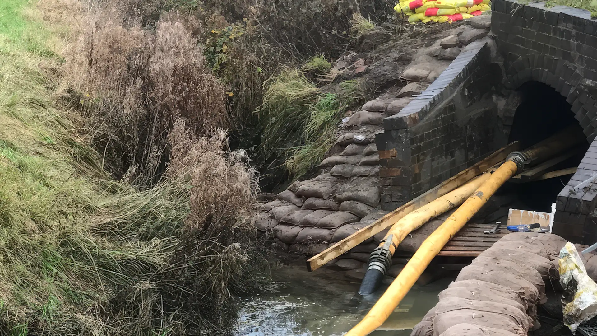 Temporary over-pumping system installed through a culvert as part of an emergency flood response and water management operation.