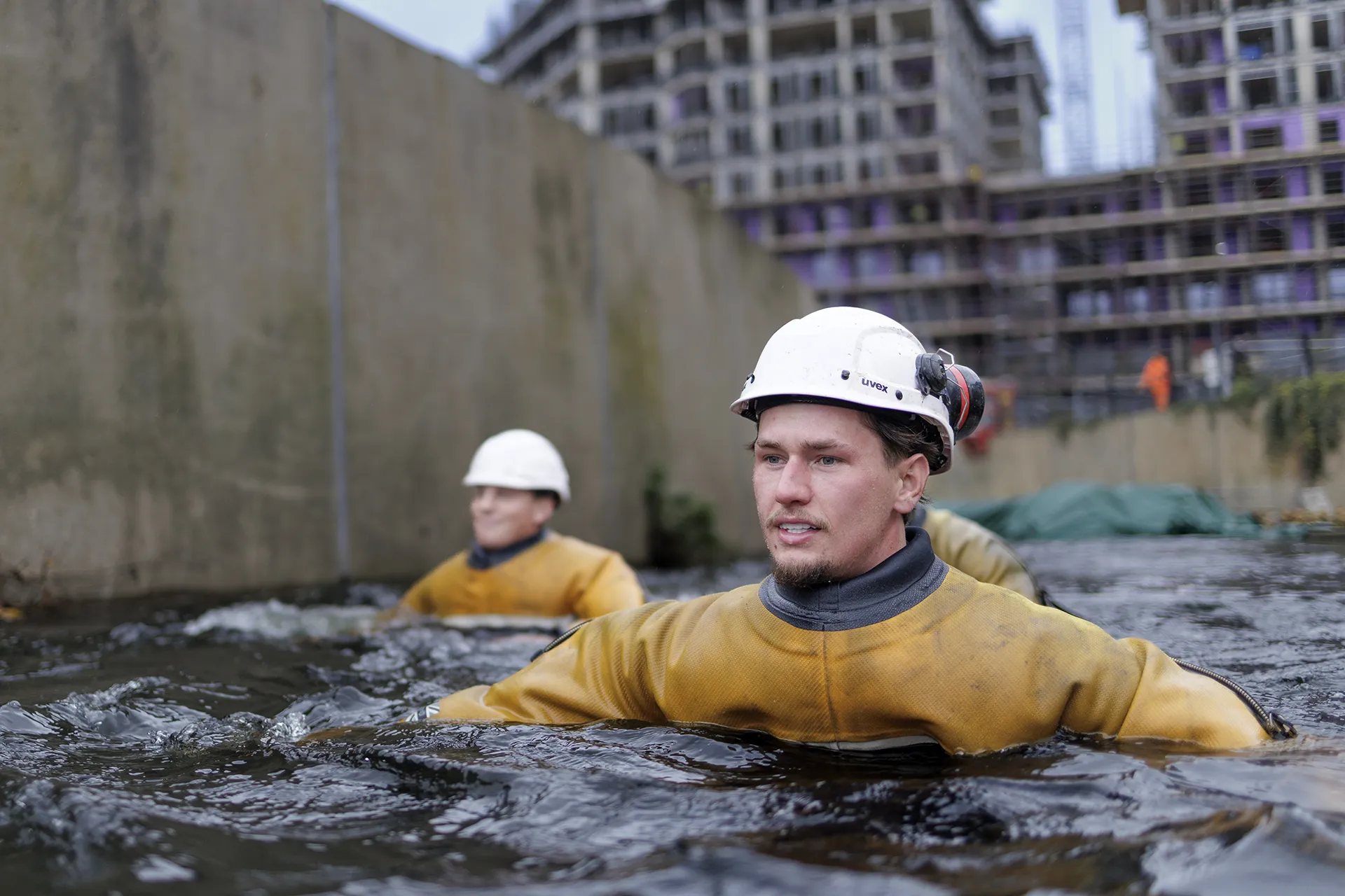 High Water engineer inspecting a temporary water control barrier within a live watercourse.