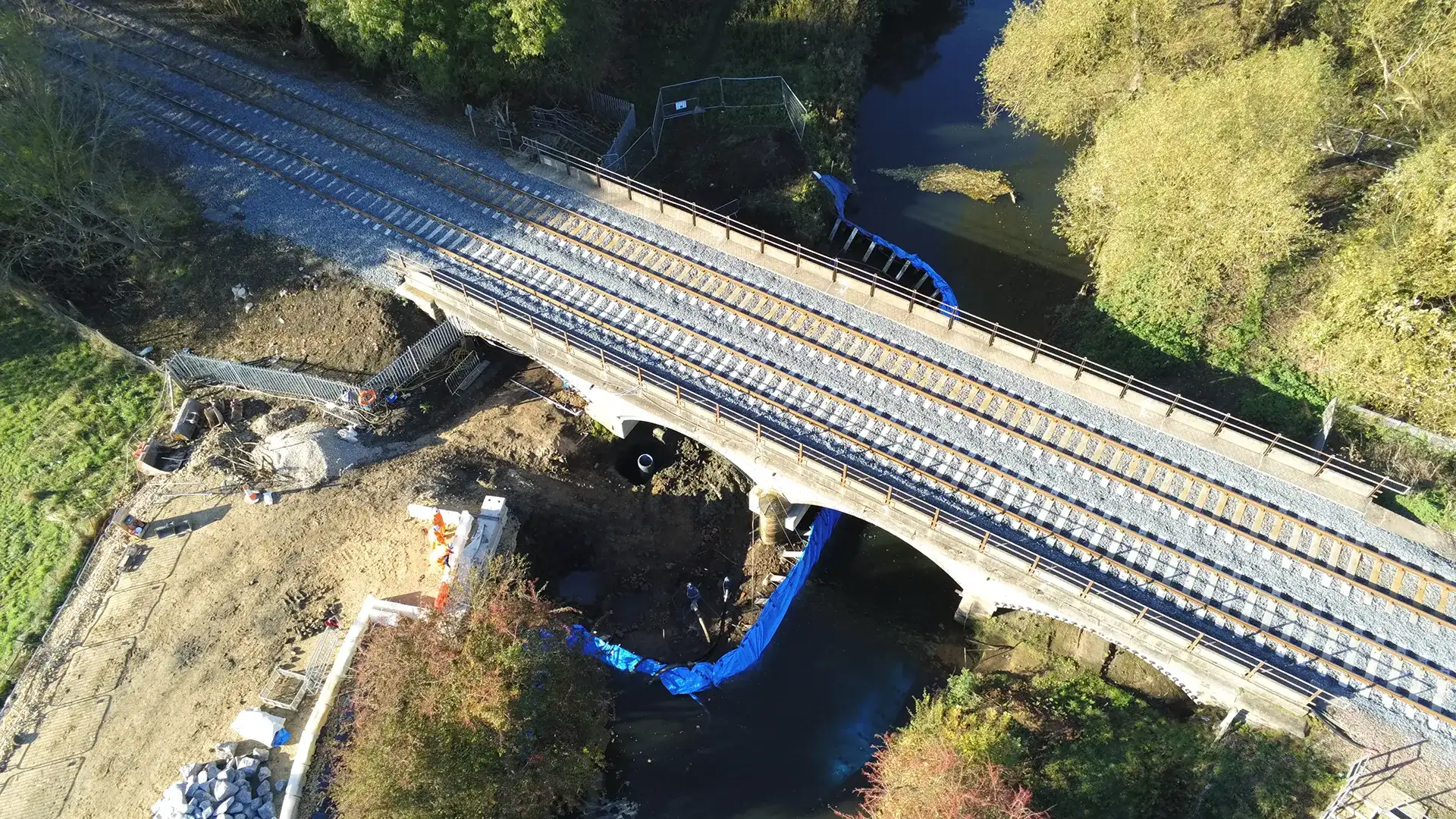 Aerial view of a limpet dam system isolating a work area beneath a railway bridge