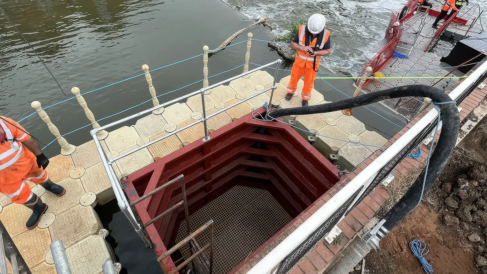 Elevated view of a limpet dam and floating pontoon system isolating a section of a waterside structure.
