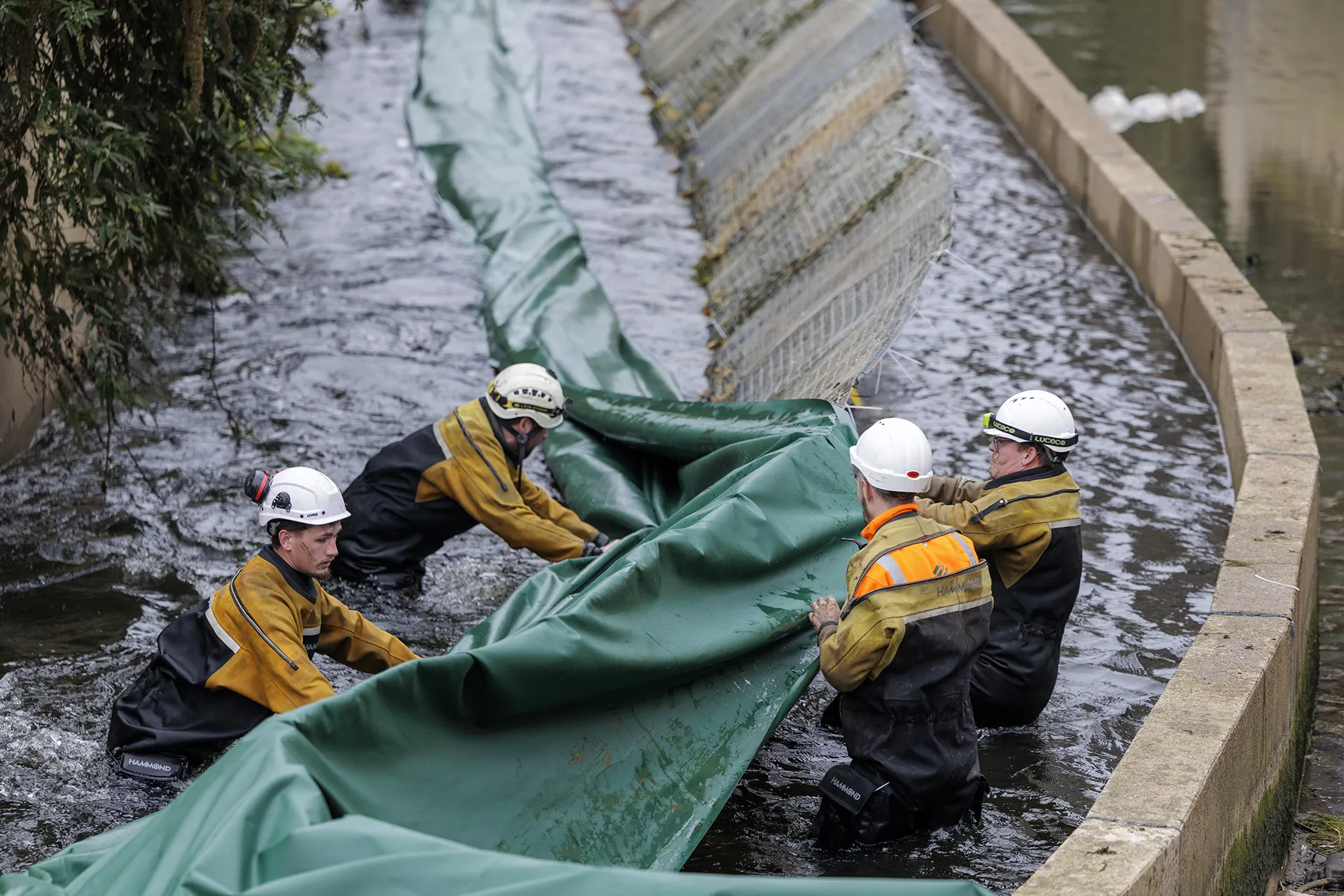 High Water engineers installing a temporary water control barrier within a canal.