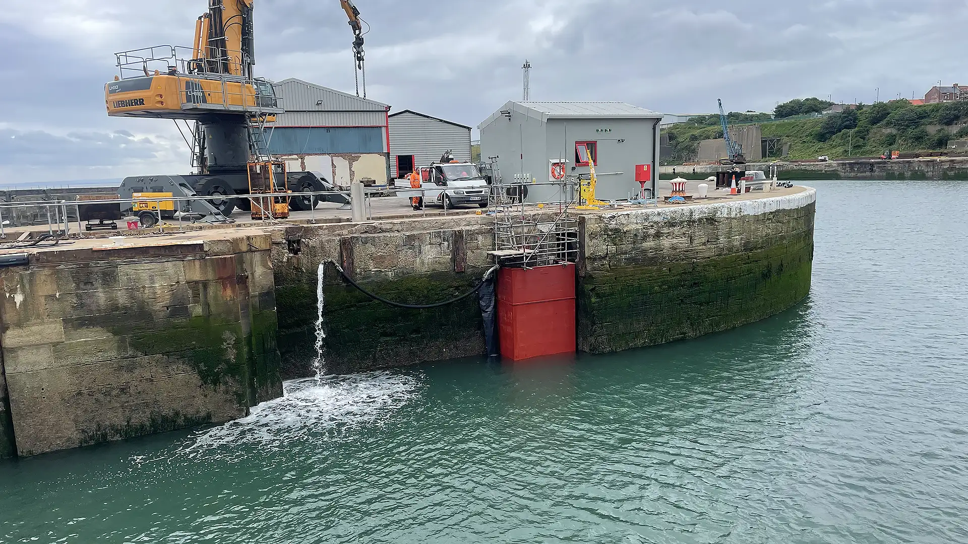 Temporary limpet dam installed within a harbour entrance to isolate a dock for inspection and maintenance.