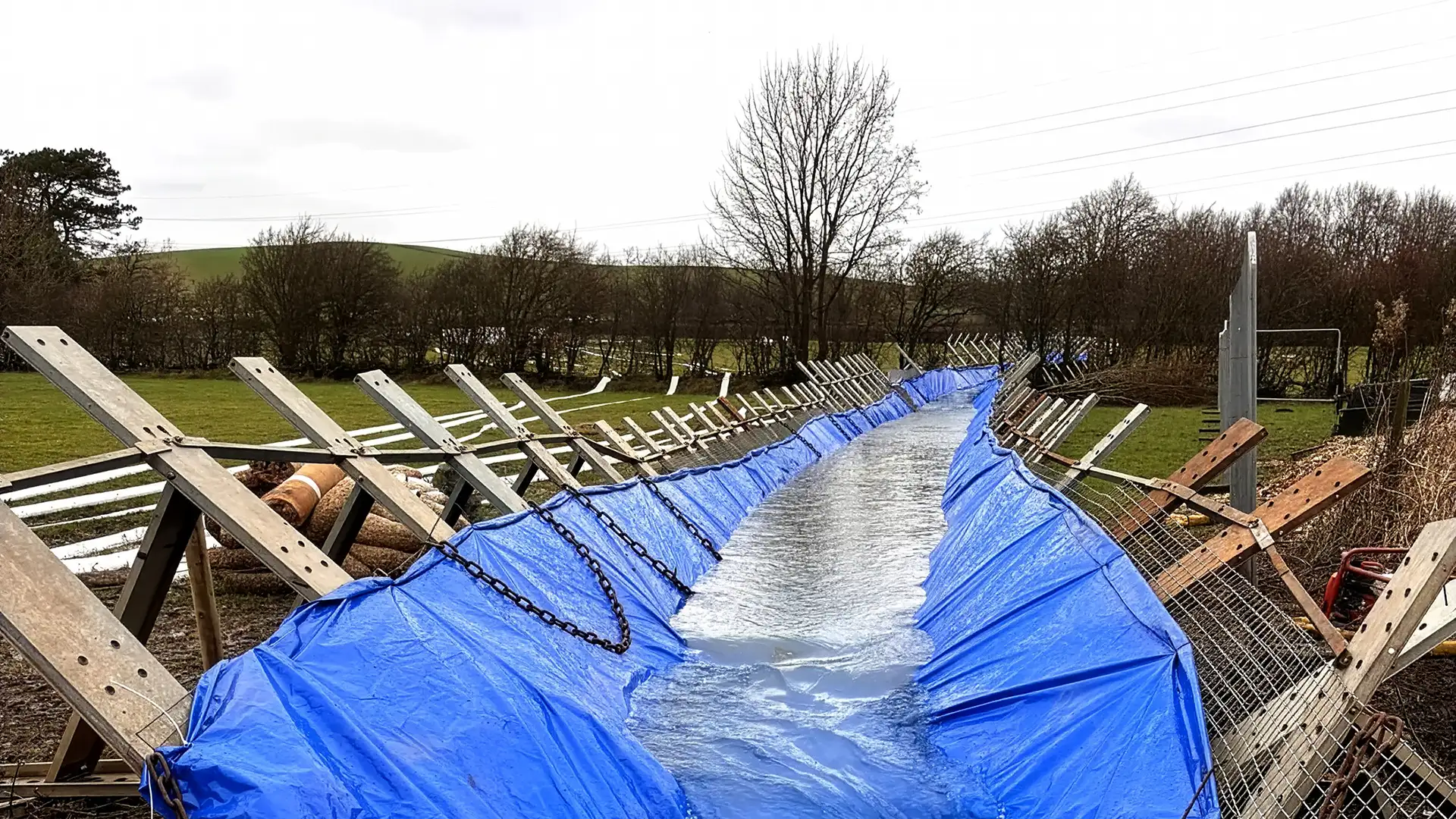 Reinforced temporary flow diversion channel directing water safely around engineering works.