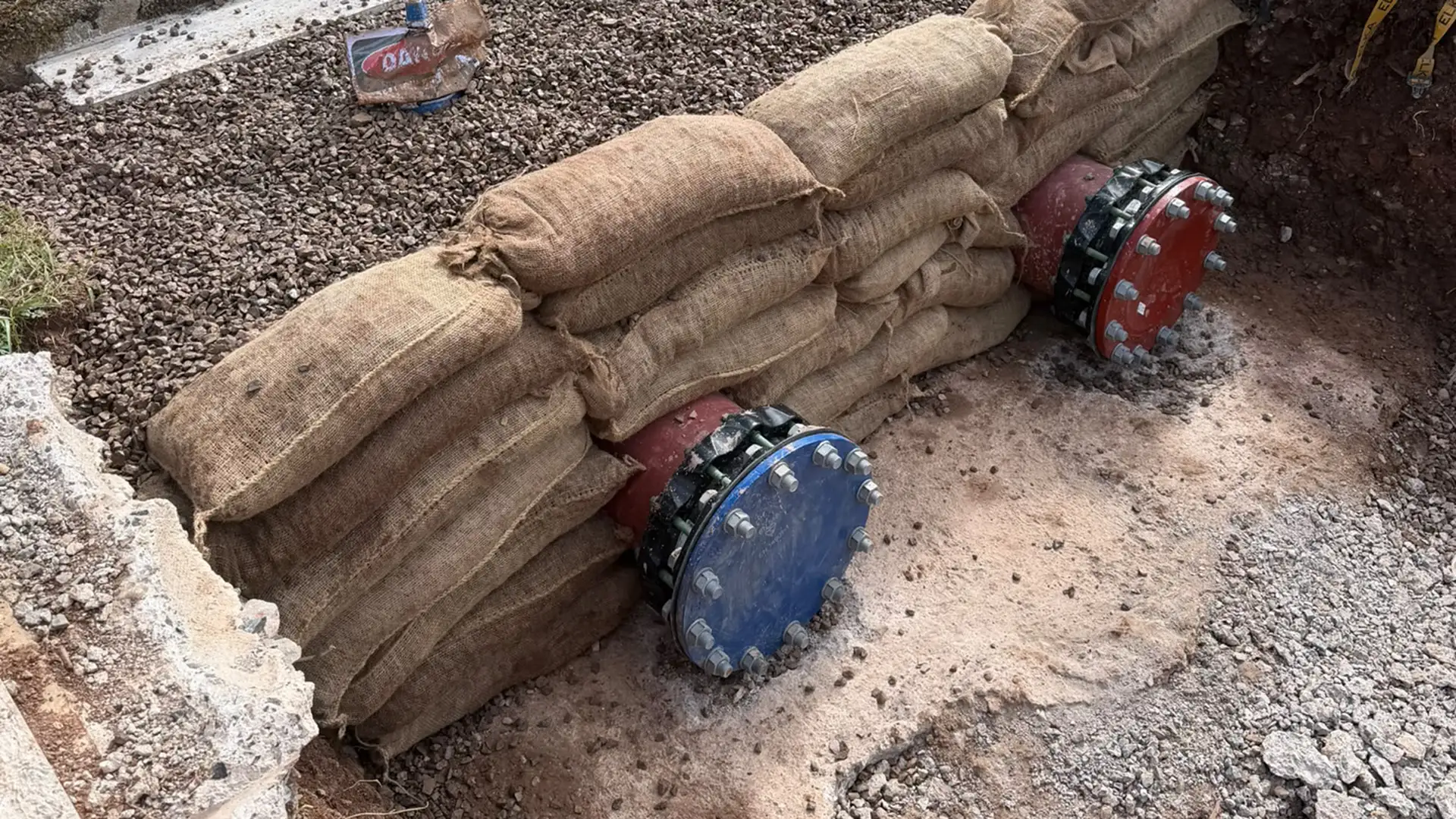 Temporary sandbag and pipeline isolation system protecting live water utility infrastructure during maintenance works.