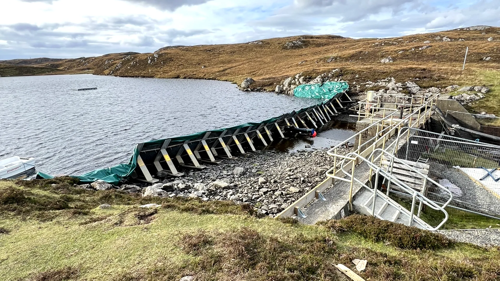 Temporary water control barrier isolating a working area beside a reservoir