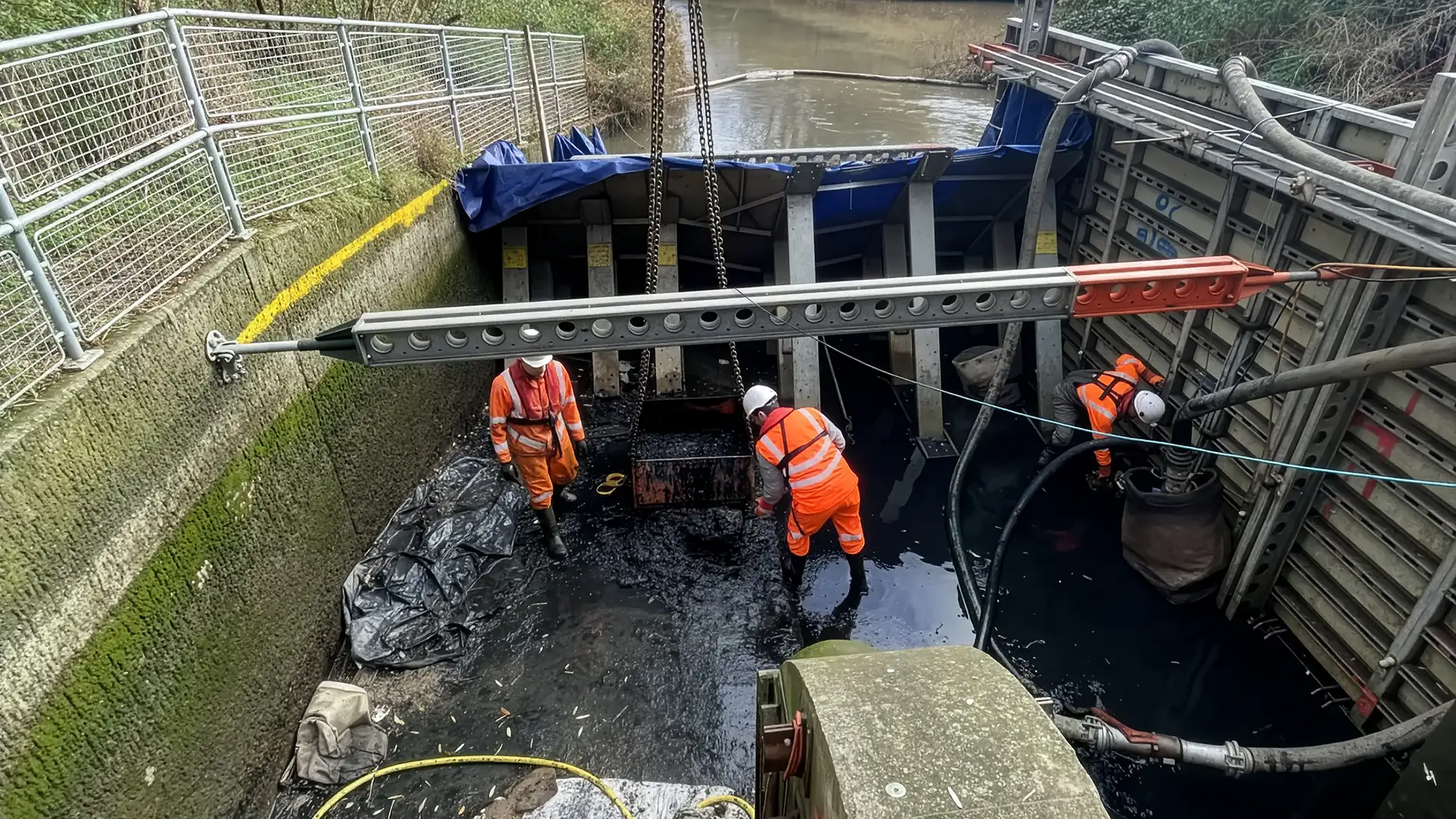 Temporary water control system under construction with engineers installing cofferdam components and dewatering equipment.