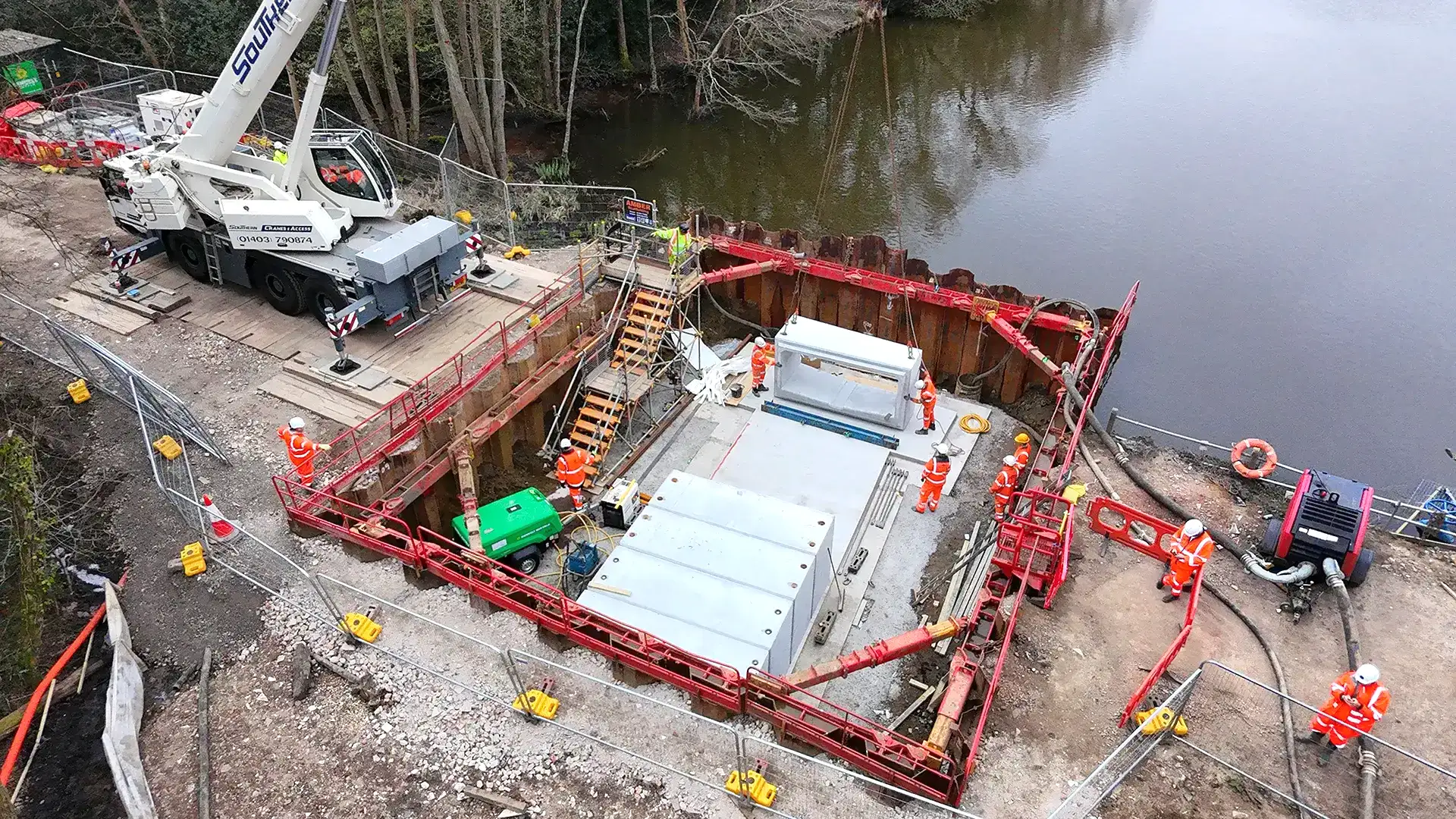 Construction team installing concrete infrastructure within a temporary water exclusion area