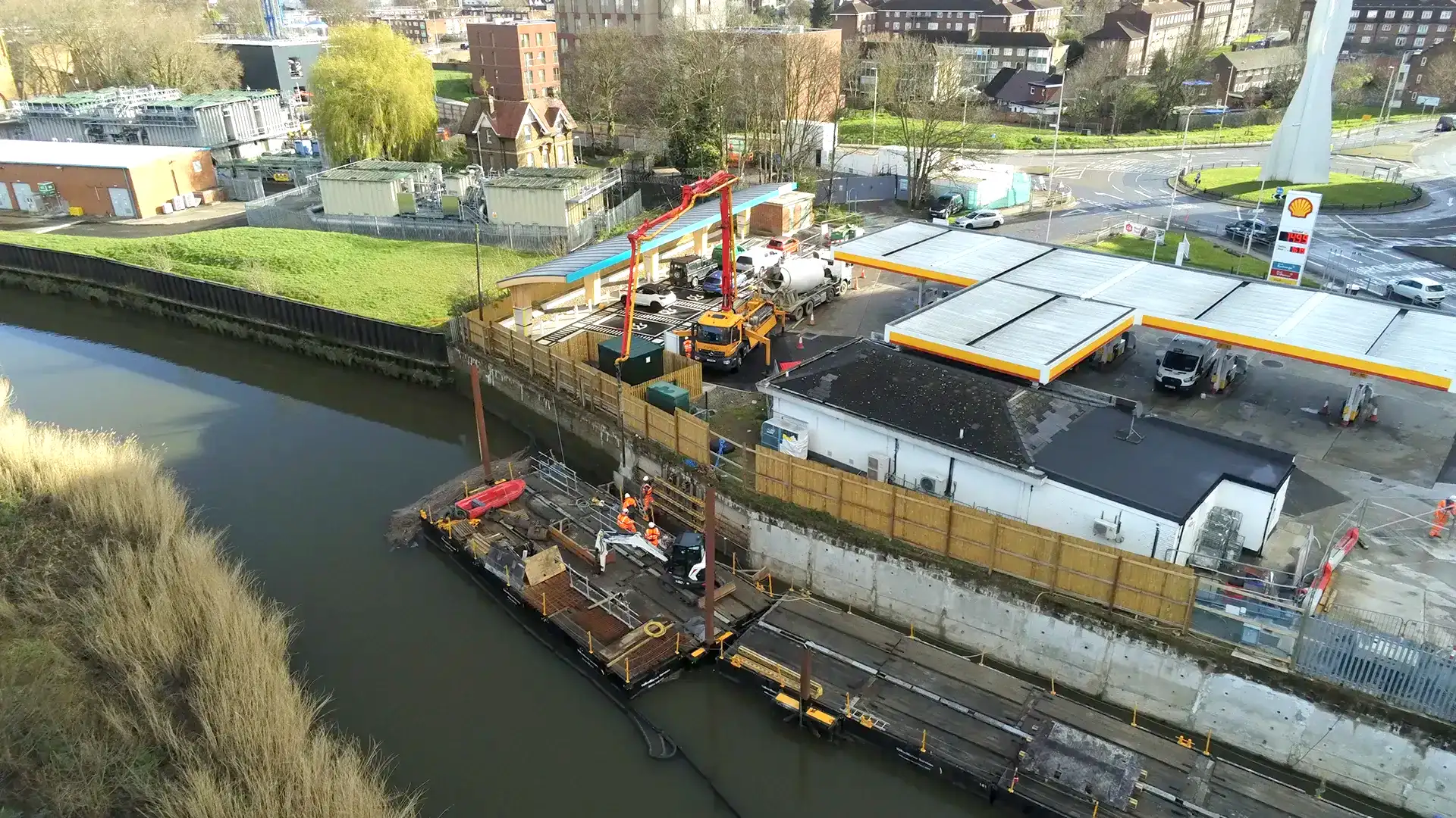 Aerial view of construction teams and floating work platforms operating in an urban canal